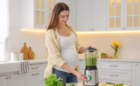 o femeie frumoasă care își prepară o rețetă de smoothie pentru gravide