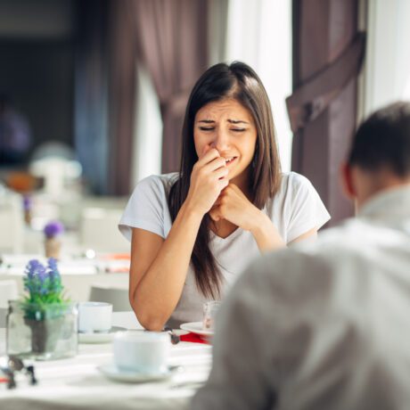 Femeie care plânge în fața unui bărbat care se află la restaurant