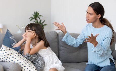 Mama supărată își cearta fiica care stă cu spatele și nu o ascultă