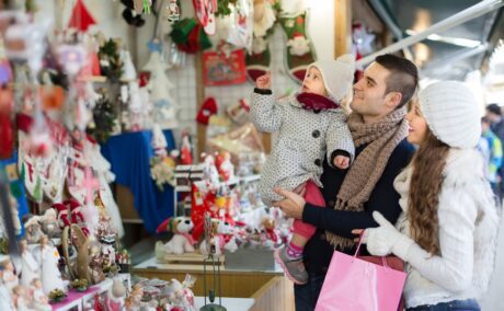 O familie care se află cu copilul la cumpărăturile de Crăciun