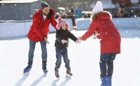 Mama, tata și fetița se distrează la patinoar