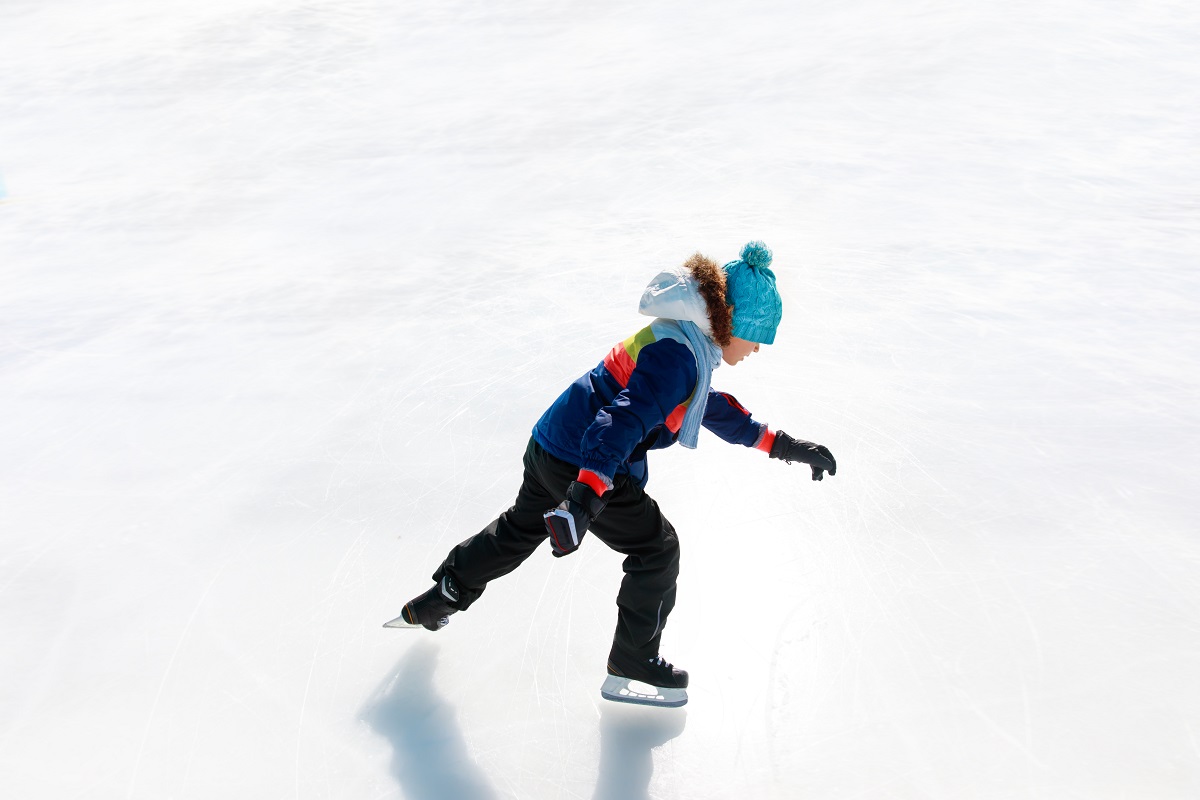 Băiat se dă cu patinele pe gheață