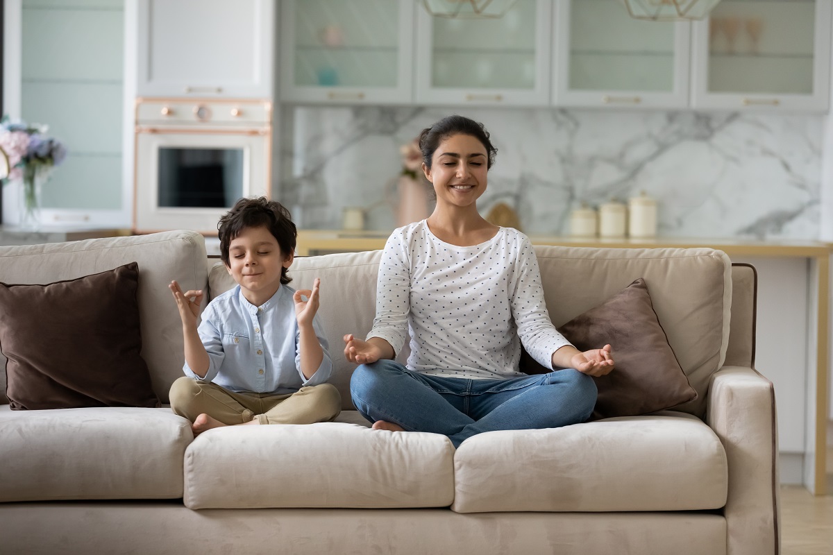 Mama și băiatul sunt pe canapea și practică tehnici de mindfulness