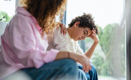 Mama stă de vorbă cu băiatul supărat pentru a-l învăța cum să-și gestioneze emoțiile în situații stresante