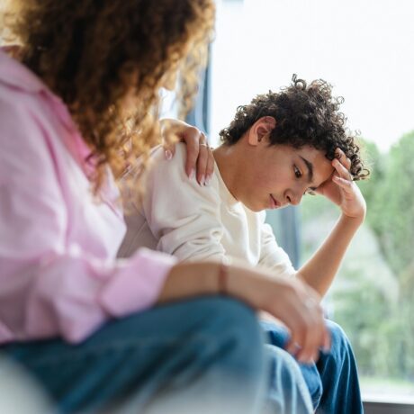 Mama stă de vorbă cu băiatul supărat pentru a-l învăța cum să-și gestioneze emoțiile în situații stresante