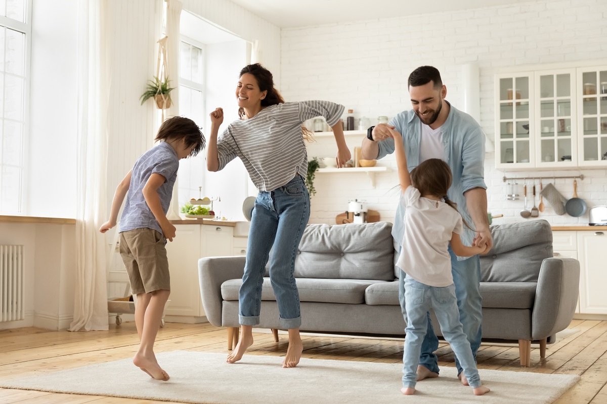 Mama, tata și cei doi copii dansează în living