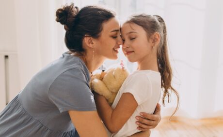 o mămică care își îmbrățișează fiica și aplică parenting blând