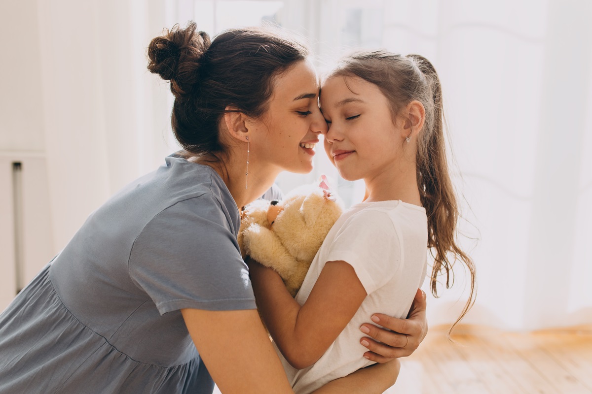 o mămică care își îmbrățișează fiica și aplică parenting blând