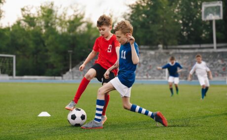 Băieți joacă fotbal