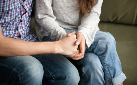 Un cuplu care se ține de mână după o împăcare în urma unei certe; sunt fericiți și relaxați că și-au salvat căsnicia.